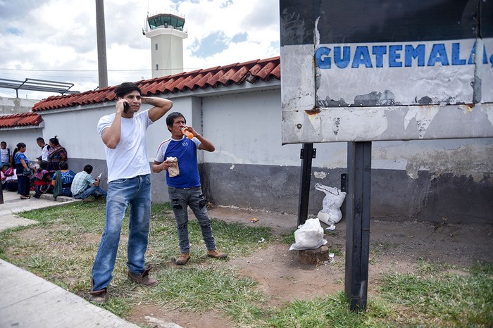 Migrantes guatemaltecos deportados de Estados Unidos permanecen fuera una base de la Fuerza Aérea después de su llegada a la Ciudad de Guatemala, el 31 de julio.  · Foto: Orlando Estrada, AFP