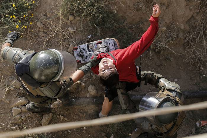 Un manifestante es detenido por carabineros el 24 de febrero de 2020, durante los enfrentamientos que estallaron en una protesta contra el presidente de Chile, Sebastián Piñera, en Viña del Mar.
 · Foto: Javier Torres, AFP