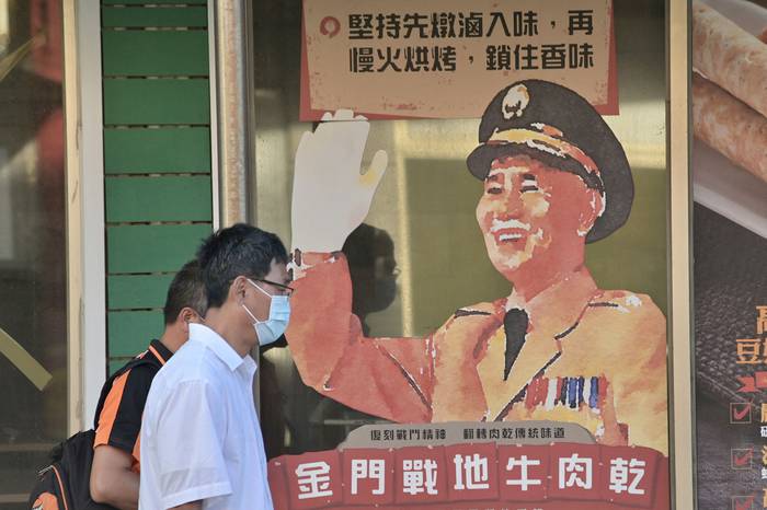 Personas caminando junto a un retrato publicitario del difunto presidente Chiang Kai-shek en las islas Kinmen. · Foto: Sam Yeh, AFP