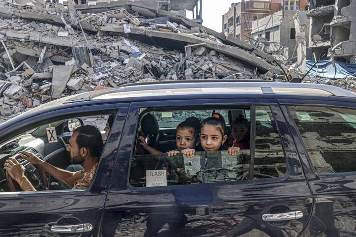 Palestinos viajan entre escombros de edificios destruidos en un ataque aéreo israelí en Rafah, en el sur de la Franja de Gaza, el 12 de octubre de 2023. · Foto: Said Khatib, AFP