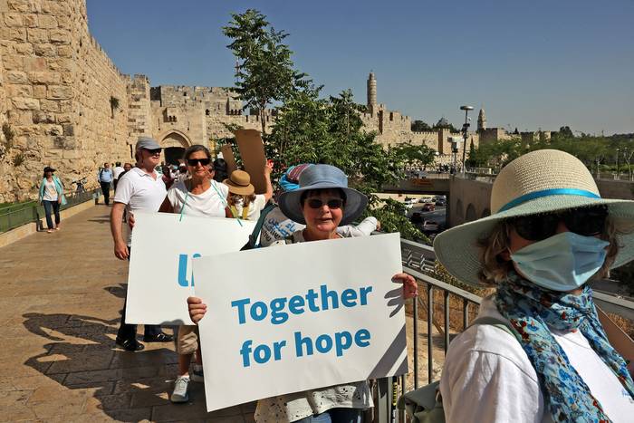 Miembros de un movimiento pacifista de base israelí, participan en una manifestación por la coexistencia y el fin del conflicto palestino-israelí, ayer, a lo largo de las murallas de la Ciudad Vieja de Jerusalén.
 · Foto: Menahen Kahana, AFP