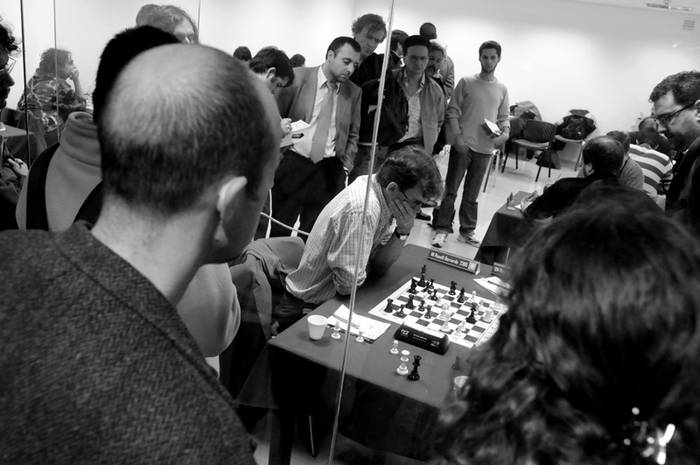 Dentro y fuera del recinto se jugó la final del campeonato uruguayo de ajedrez, en el subsuelo de la Torre Ejecutiva, el público sigue la partida entre Bernardo Roselli (al centro) y Andrés Rodríguez · Foto: Ricardo Antúnez