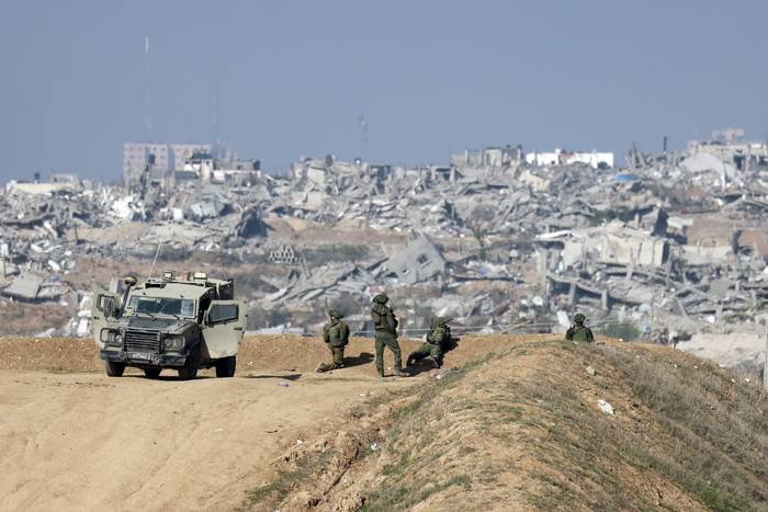 Soldados israelíes observan la ciudad de Gaza, el 1° de enero de 2024. · Foto: Menahen Kahana, AFP