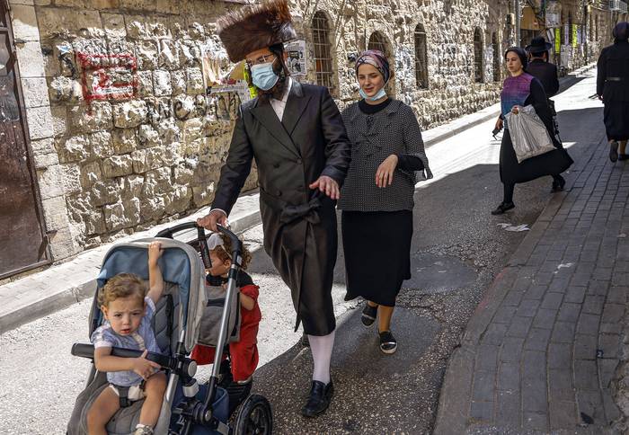 Una familia judía en una calle del barrio ultraortodoxo de Mea Shearim en Jerusalén, ayer, antes del inicio de Yom Kipur, el El día santo judío de la Expiación.
 · Foto: Menahen Kahana, AFP