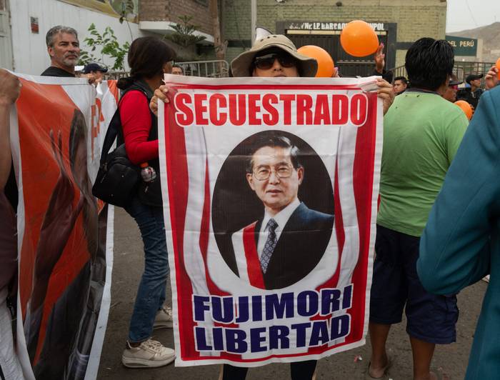 Partidarios del expresidente peruano Alberto Fujimori, en la entrada de la prisión de Barbadillo, exigiendo su liberación, en las afueras del este de Lima, el 5 de diciembre. · Foto: Cris Bouroncle, AFP