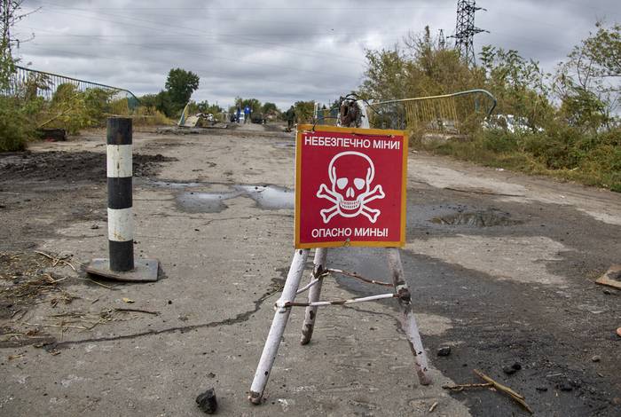 Un cartel reza "Peligro de minas" en una carretera cerca de la recién reconquistada ciudad de Balakliia en la zona de Kharkiv, Ucrania, el 13 de septiembre de 2022. · Foto: Sergey Kozlov, EFE
