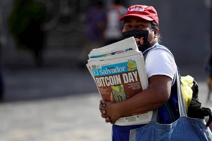 Una mujer vende periódicos donde se anuncia la entrada en vigencia del Bitcoin, en El Salvador. · Foto: Rodrigo Sura, EFE