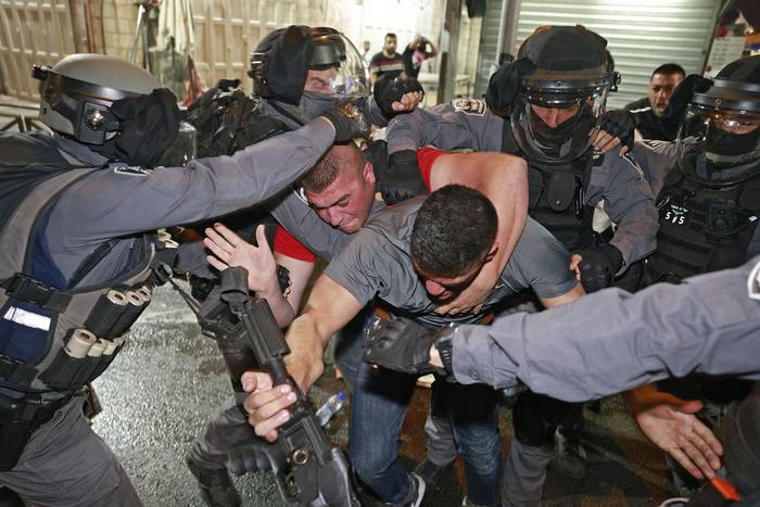 Integrantes de las fuerzas de seguridad israelíes reprimen a manifestantes palestinos
fuera de la Puerta de Damasco en la Ciudad Vieja de Jerusalén, el 9 de mayo.
 · Foto: Menahen Kahana, AFP