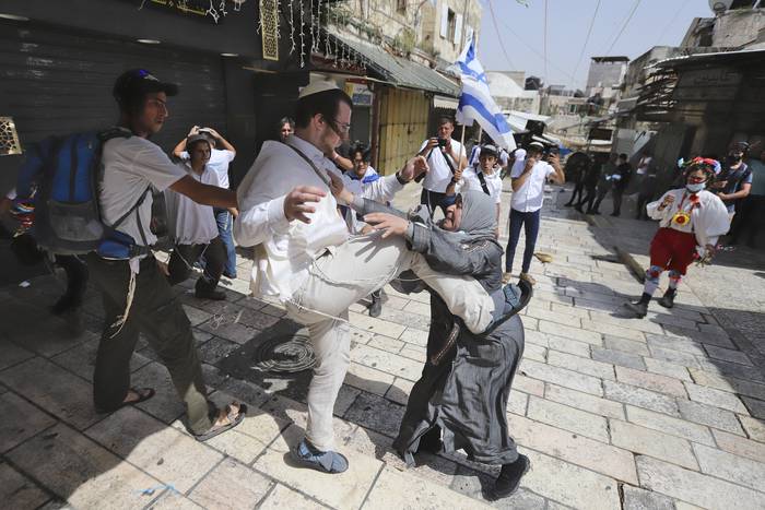 Una mujer palestina es atacada por un ultranacionalista religioso israelí en el interior de la Puerta de Damasco, en el Barrio Musulmán de la Ciudad Vieja de Jerusalén, durante la Marcha de las Banderas. · Foto: Quique Kierszenbaum