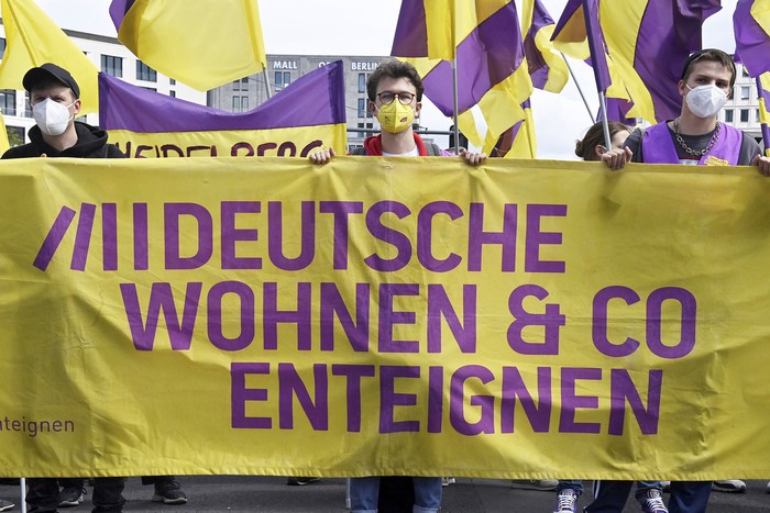Manifestantes con una pancarta que dice “Expropiar Deutsche Wohnen & Co", durante una manifestación contra el aumento del precio de los alquileres en Berlín, el 23 de mayo de 2021. · Foto: John Macdougall, AFP