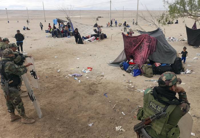Policías peruanos hacen guardia en un campamento de migrantes en la frontera entre Perú y Chile (27.04.2023). · Foto: Javier Rumiche, AFP