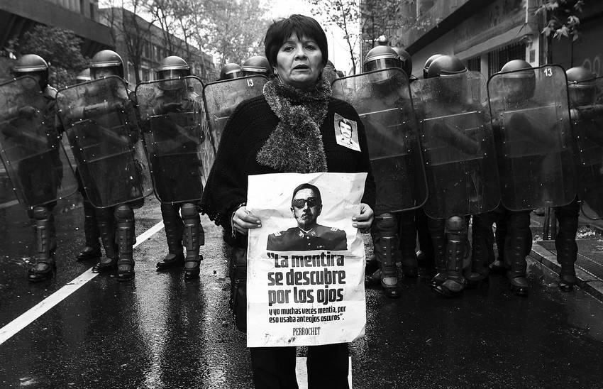 Una manifestante contraria al fallecido dictador chileno Augusto Pinochet, en las inmediaciones del teatro Caupolicán en Santiago de Chile, lugar elegido por la Corporación 11 de Septiembre para la exhibición de un documental en favor del dictador.