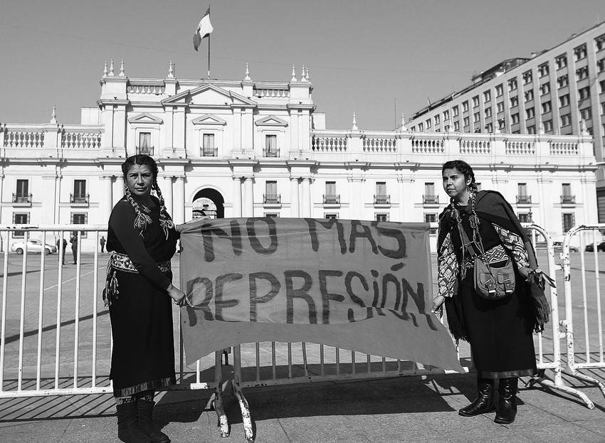 Dos mujeres mapuches de Ercilla, localidad distante 600 kilómetros de Santiago, reclaman el cese de la represión en sus regiones, ayer, en las afueras del Palacio de La Moneda, mientras se desarrollaba una reunión de seguridad convocada por el gobierno.