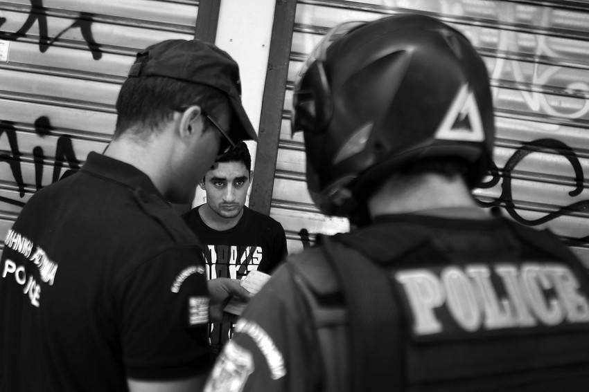 Dos policías revisan la documentación de un inmigrante que vive en Atenas, Grecia, durante la operación Xenios Zeus, que consiste en redadas a gran escala a inmigrantes sin papeles. 