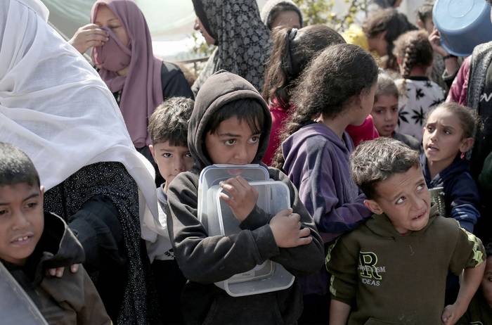 Niños palestinos desplazados esperan comida, en Rafah, Franja de Gaza (28.02.2024). · Foto: AFP