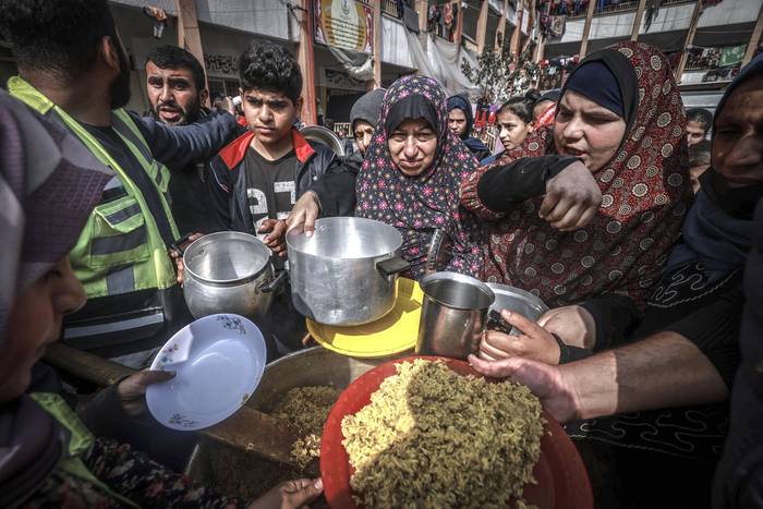 Palestinos desplazados reciben comida en una escuela gubernamental, ayer, en Rafah, Franja de Gaza. · Foto: Mohammed Abed, AFP