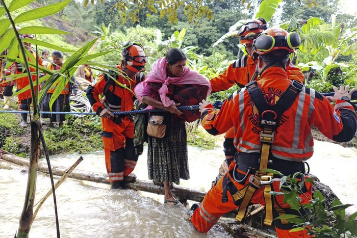 Bomberos evacúan personas atrapadas por un deslizamiento de tierra, luego del paso de la tormenta tropical Julia, en el pueblo de Queja, Guatemala, el 10 de octubre de 2022. 
Foto: Bomberos de Guatemala, AFP
