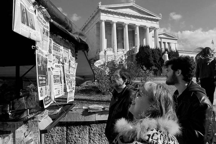 Varias personas leen las portadas de periódicos que reflejan la victoria de Syriza en las elecciones, ayer, en un quiosco en Atenas, Grecia.
Foto: Orestis Panagiotou, Efe