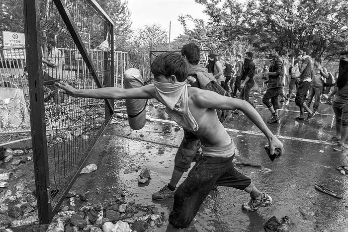 Migrantes lanzan piedras y tratan de abrir los portones, ayer, en la frontera de Hungría con Serbia, cerca de la ciudad de Horgos. Foto: Armend Nimani, Afp