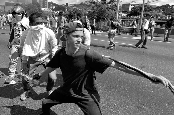 Un activista de la oposición participa en un enfrentamiento con la Policía antidisturbios,
ayer, en Caracas, Venezuela. Foto: Federico Parra, Afp