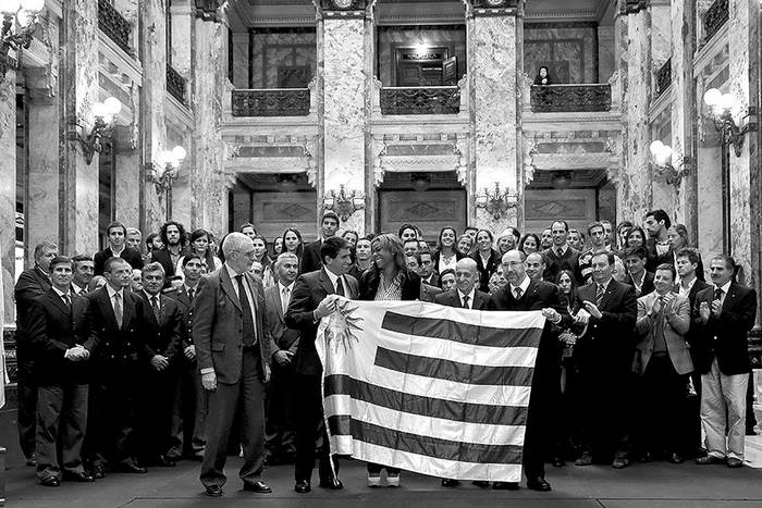 Atletas de la delegación uruguaya que competirá en los Juegos Panamericanos de Toronto 2015 reciben la bandera uruguaya, el martes, en el Palacio Legislativo. Foto: Parlamento, s/de Autor