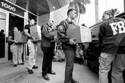 Agentes del FBI llevan documentos de la sede de la Concacaf, durante el allanamiento, ayer, en Miami Beach, Florida. Foto: Joe Skipper, Afp