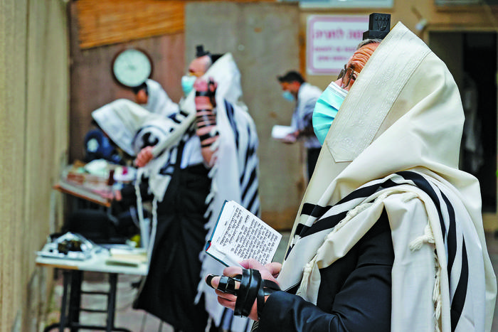 Judíos ultra ortodoxos, rezan en el estacionamiento frente a una sinagoga, en Tel Aviv, Israel, el 13 de enero.  · Foto: Jack Guez, AFP
