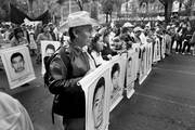 Manifestantes con los rostros de los 43 estudiantes que desaparecieron hace tres meses en el estado mexicano de Guerrero, durante una marcha el viernes 26 de diciembre,
en Ciudad de México. Foto: Jorge Núñez, Efe