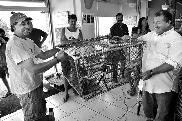 Omar Bentancur y Alfredo Hargain, pescadores artesanales de Piriápolis, presentan una de las nasas,
ayer en el restaurante Roma Amor del balneario. Foto: Iván Franco