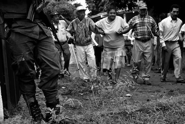 Un soldado custodia la llegada de ciudadanos a uno de los centros de votación, en el municipio de Corinto, al norte de Cauca, en las elecciones regionales y locales que se desarrollaron ayer en Colombia. 