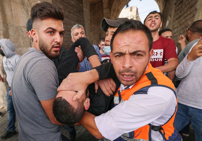 Médicos palestinos evacuan a un manifestante herido en medio de enfrentamientos con las fuerzas de seguridad israelíes, ayer, en la Ciudad Vieja de Jerusalén.
 · Foto: Emmanuel Dunand, AFP