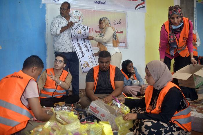 Voluntarios preparan paquetes de ayuda para refugiados que huyen de Sudán, en la estación de autobuses de Wadi Karkar (02.05.2023). · Foto: AFP