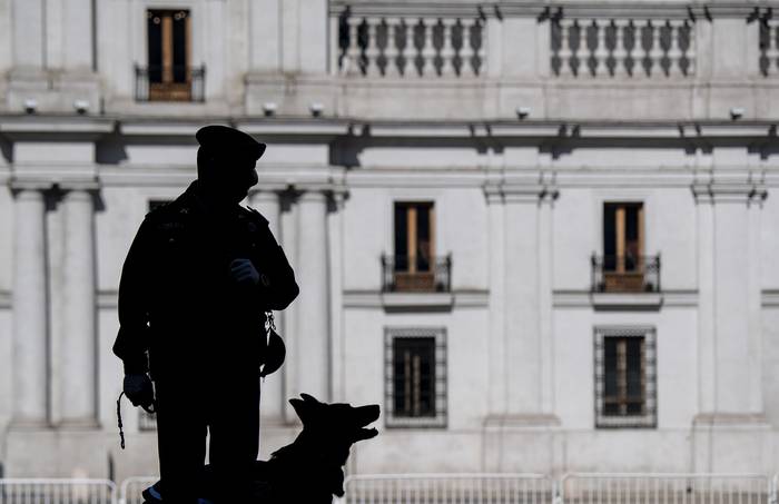 Un policía hace guardia frente al palacio presidencial de La Moneda, en Santiago de Chile. · Foto: Martín Bernetti, AFP