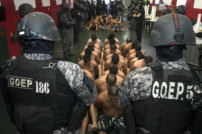 Reclusos custodiados por miembros del Grupo de Operaciones Penitenciarias Especiales, mientras realizan una búsqueda en la cárcel de Piñero, cerca de Rosario en la provincia de Santa Fe. · Foto: Gobierno de Santa Fe, AFP