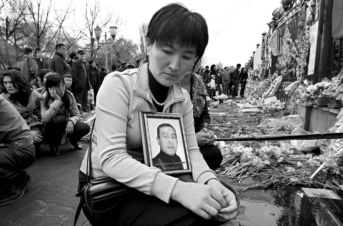 Una mujer kirguís sostiene la foto de una de las víctimas de los disturbios, Nurlan Beysheev, de 34 años, durante una concentración llevada a cabo delante de la sede del gobierno en Biskek (Kirguistán).