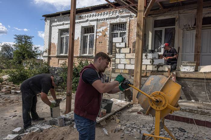 Reparación de una escuela primaria que resultó gravemente dañada durante los ataques rusos, en Hostomel, al noroeste de la ciudad capital de Kiev, Ucrania (18.07.2022). · Foto: Roman Pilipey, EFE