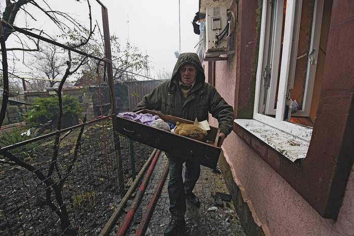 Residentes y vecinos sacan pertenencias de una casa afectada por un reciente bombardeo en la región ucraniana de Donetsk, controlada por Rusia, el 30 de noviembre. · Foto: Stringer, AFP