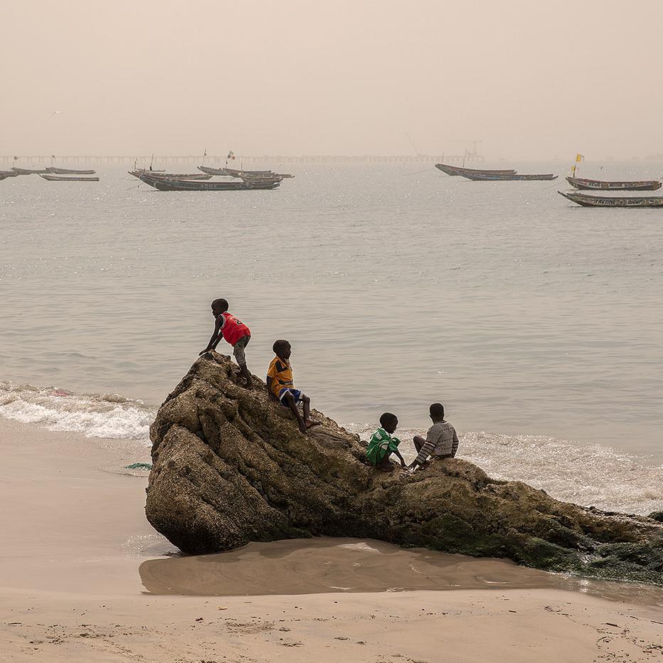 Niños juegan en una antigua barrera construida alrededor de 1988 para detener el avance del mar, en Bargny.