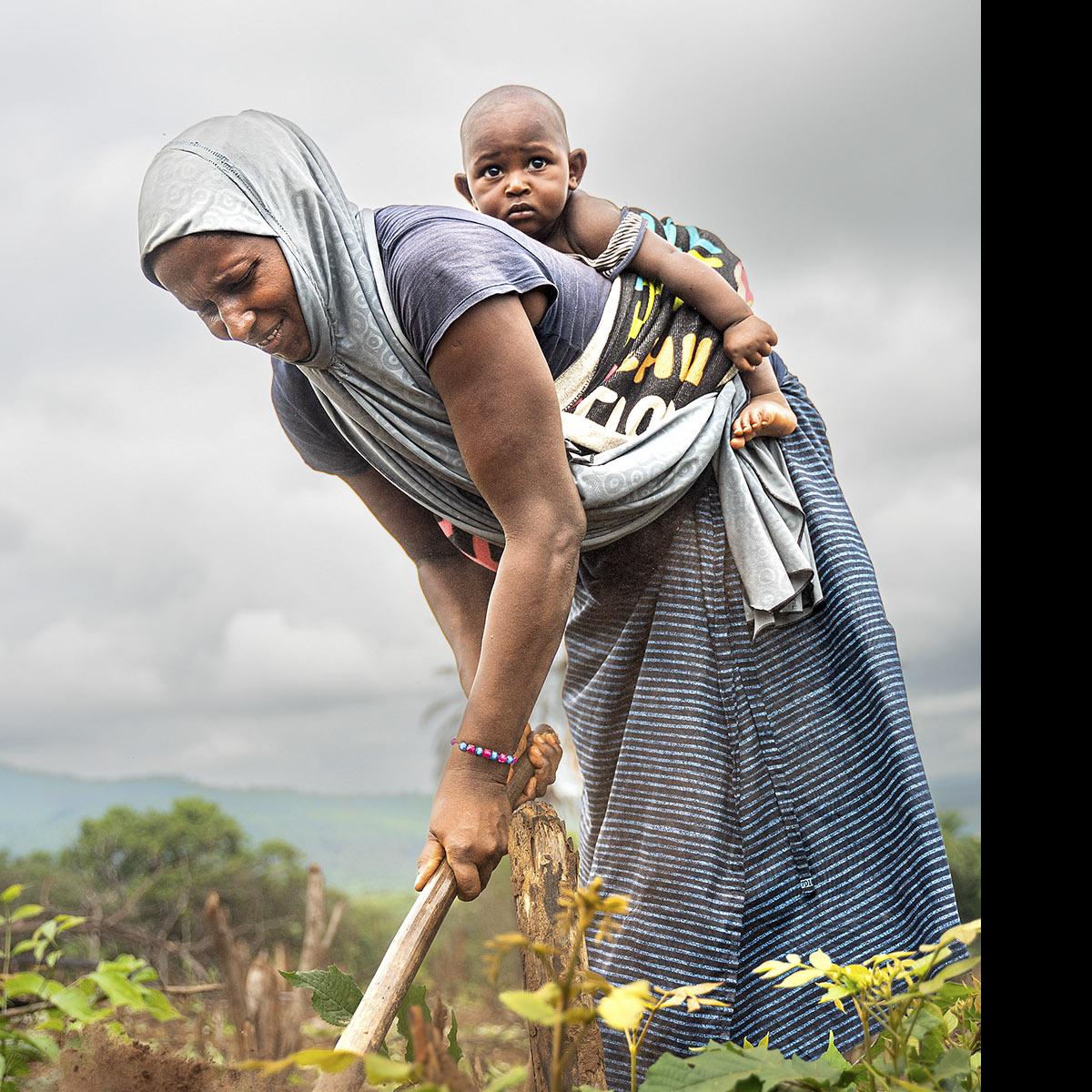 Aissatou con su hĳo más pequeño en la huerta familiar. · Foto: Franca Levin