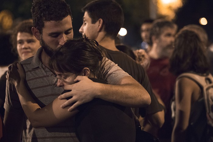 Amigos y familiares de Marielle Franco esperan los procedimientos de la Policía Civil de Río en el automóvil de Marielle, donde fue encontrada muerta a tiros en Río de Janeiro, hoy. Foto: Mauro Pimentel / AFP