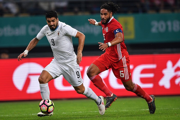 Luis Suárez y Ashley Williams, durante la final de la China Cup 2018, en Nanning. Foto: s/d de autor /AFP (Archivo, 2018)