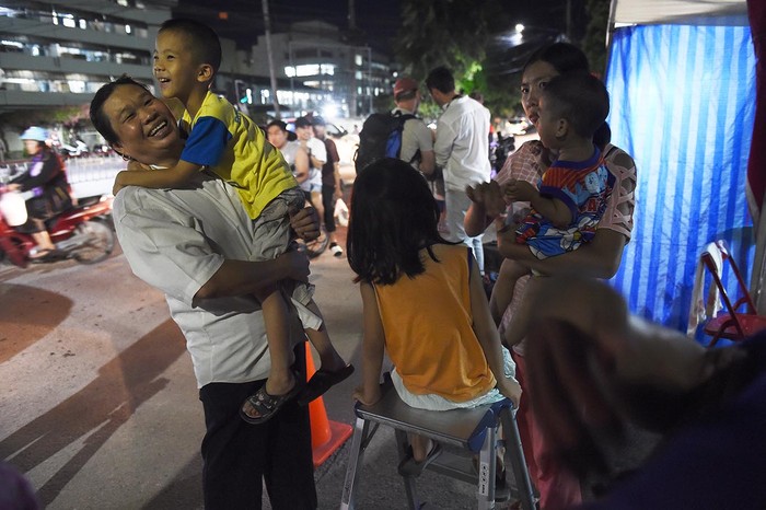 La gente reacciona cerca de un hospital, donde los miembros del equipo de fútbol infantil reciben tratamiento después de ser rescatados, en Chiang Rai. Los 12 niños y su entrenador de fútbol atrapados en una cueva en el norte de Tailandia durante más de quince días han sido rescatados tras una misión de tres días sin precedentes que tenía todas las características de una película de gran éxito. Foto: Lilian Suwanrumpha / AFP.
