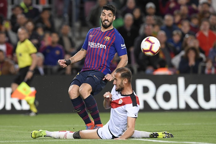 Luis Suárez, de Barcelona, y Alex Galvez, de Rayo Vallecano, en el estadio Nou Camp en Barcelona.  · Foto: Lluis Gene