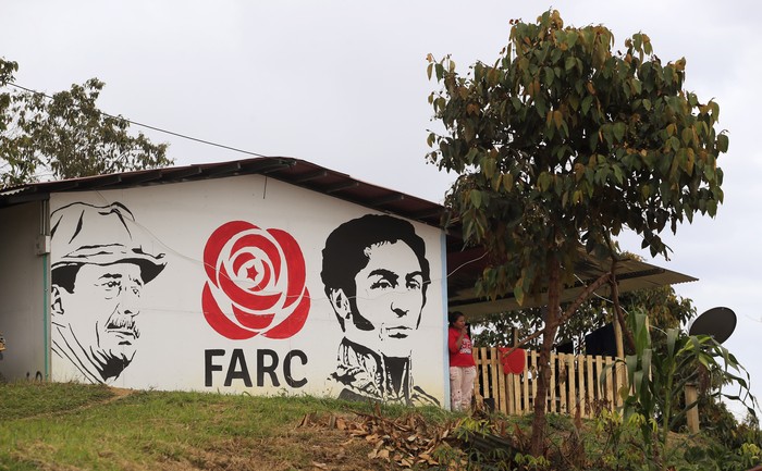 Un mural de las Fuerzas Armadas Revolucionarias de Colombia con los rostros de Simon Trinidad y Simón Bolivar, en una zona de desmovilización en Tolima. · Foto: Daniel Muñoz, AFP