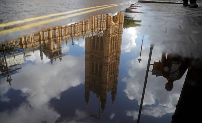 La Cámara de los Comunes se refleja en un charco de lluvia en Londres. · Foto: Tolga Akmen, AFP