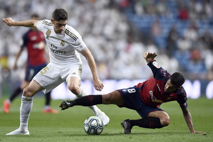 El uruguayo del Real Madrid, Federico Valverde, y Fran Merida, del Osasuna, durante el partido de fútbol de la liga española en el estadio Santiago Bernabeu. OSCAR DEL POZO / AFP