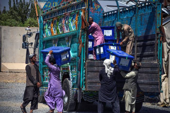 Trabajadores de la Comisión Electoral Independiente de Afganistán descargan las urnas de un camión y las llevan a uno de los centros de conteo de votos · Foto: Javed Tanveer, AFP