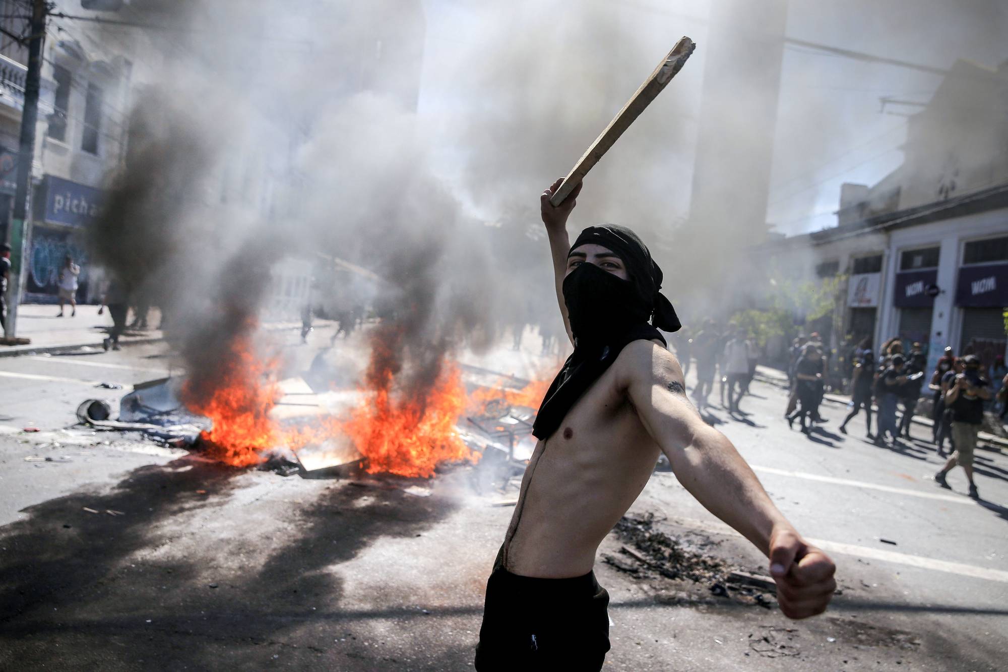 Manifestantes se enfrentan a la Policía antidisturbios por cuarto día consecutivo en las protestas contra un aumento (ahora suspendido) en los precios de los boletos de metro, en Valparaíso, Chile, el 21 de octubre.