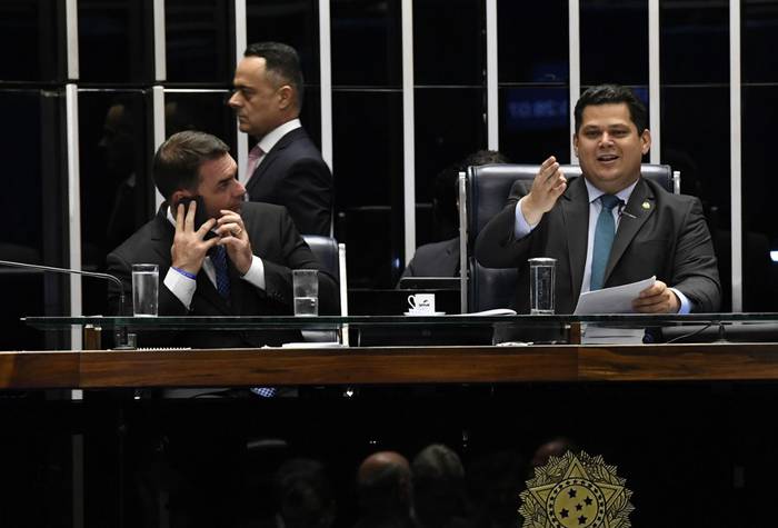 El senador e hijo del presidente, Flávio Bolsonaro (izquierda), y el presidente de la cámara alta de Brasil, Davi Alcolumbre, durante la sesión en la que se aprobó la reforma jubilatoria. Foto: Jefferson Rudy, Senado de Brasil, AFP

