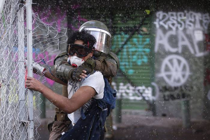 Un manifestante es arrestado durante la llamada 'Marcha de luto', ayer, en Santiago. · Foto: Claudio Reyes, AFP
